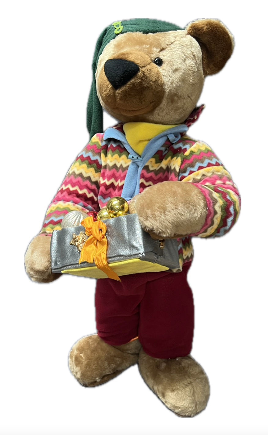 Teddybär mit grüner Mütze und Geschenkpaket mit Kugeln