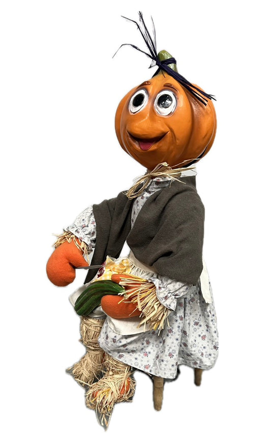 Pumpkin girl sitting with cucumber